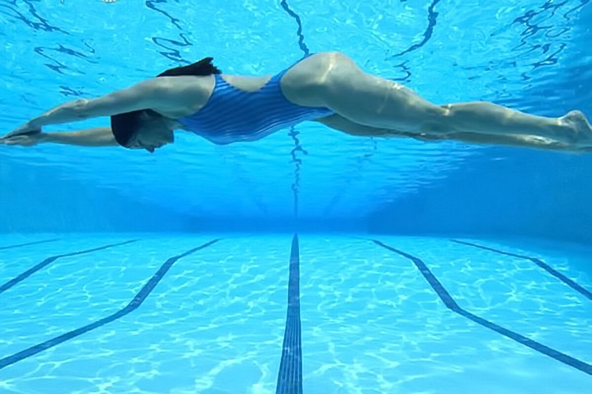 woman swimming in pool underwater Why You Should Exercise During Menstruation