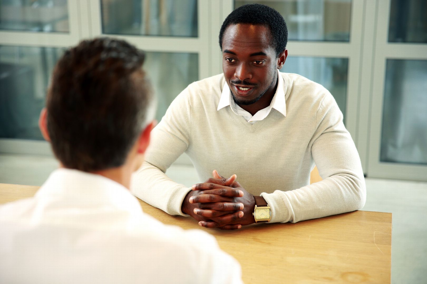 Two business people sitting at the table and talking in office