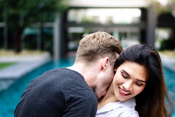 Man kisses woman's neck